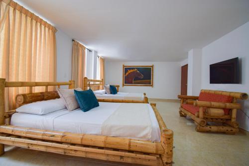 Un dormitorio con 2 camas y una silla. en Hotel Toledo Plaza, en Armenia