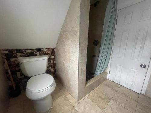 Private Loft 5 min away from LGA في East Elmhurst: حمام مع مرحاض أبيض ودش