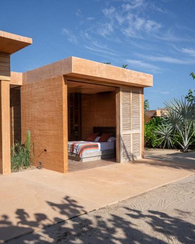 a bed in a building with a patio at Mazul Puerto Escondido in Tlachicón