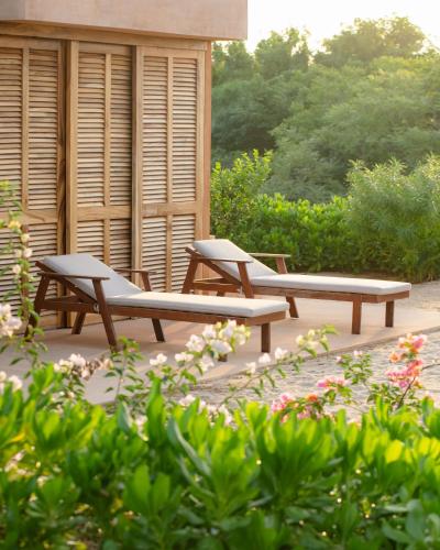 two benches sitting on a patio in a garden at Mazul Puerto Escondido in Tlachicón