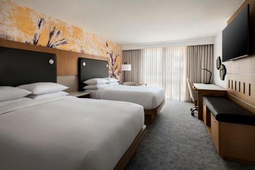 a hotel room with two beds and a television at Westchester Marriott in Tarrytown