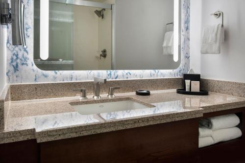 a bathroom with a sink and a large mirror at Westchester Marriott in Tarrytown