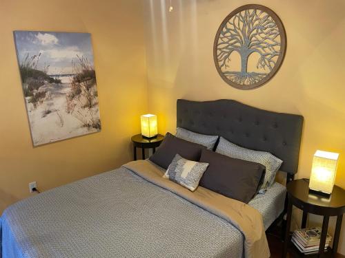 a bedroom with a bed with two lamps and a tree on the wall at Beach Casita - Allyn Inn in Shelton
