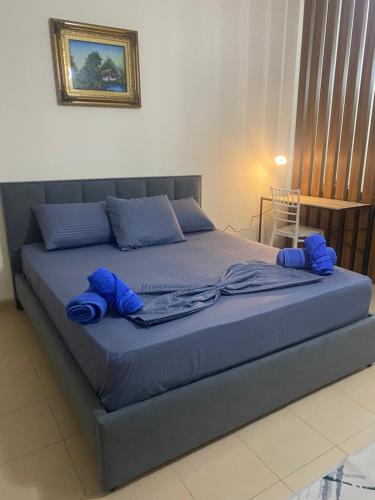 ein Bett mit blauer Bettwäsche und Kissen darauf in der Unterkunft Chlo apartment 4 Tirane in Tirana
