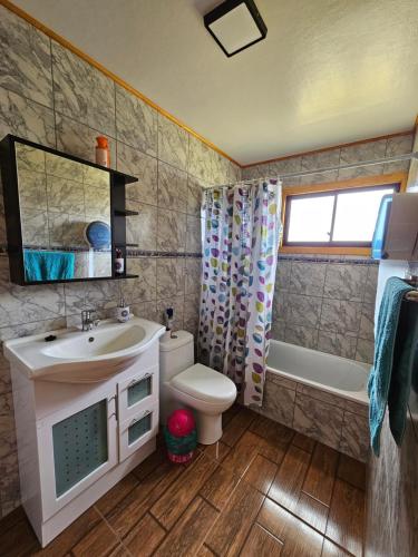 y baño con lavabo, aseo y bañera. en Casa familiar en Isla Lemuy en Puqueldón