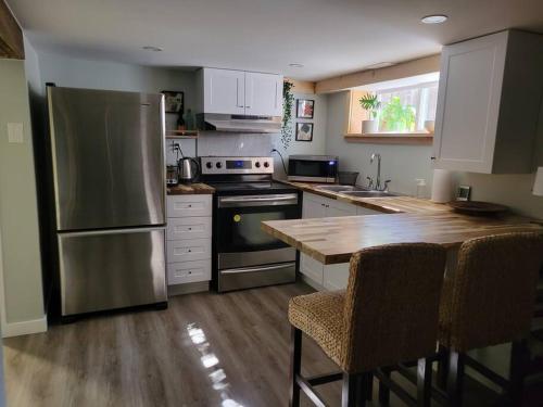 a kitchen with a stainless steel refrigerator and a wooden table at 1 bedroom basement apartment with free parking in Brampton