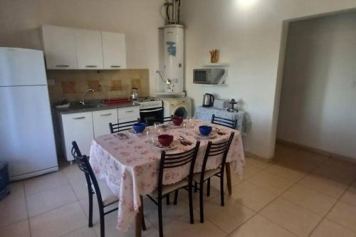 een keuken met een tafel met stoelen en een koelkast bij El Refugio in El Calafate