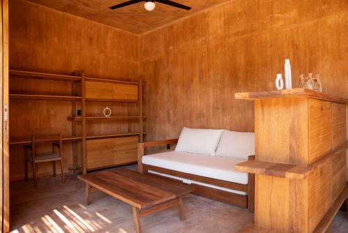 a small room with a bed and a table at Mazul Puerto Escondido in Tlachicón