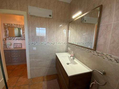 ein Bad mit einem Waschbecken und einem Spiegel in der Unterkunft Casa Hollandia in Viñuela