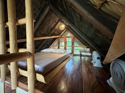 een bed in een zolderkamer bij Casa AVA in Mazunte