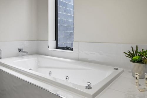 a white bath tub in a bathroom with a window at York St Apartments in Geelong