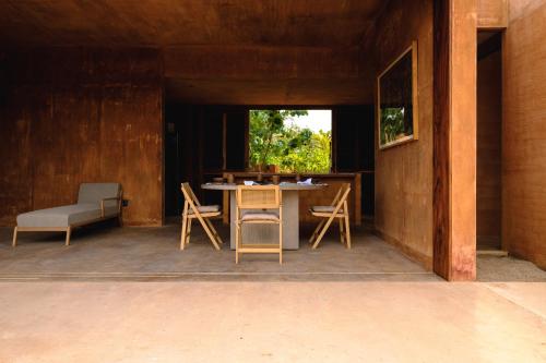 a patio with a table and chairs and a window at Mazul Puerto Escondido in Tlachicón