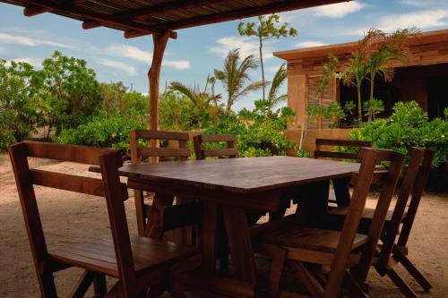 a wooden table and chairs on a patio at Mazul Puerto Escondido in Tlachicón