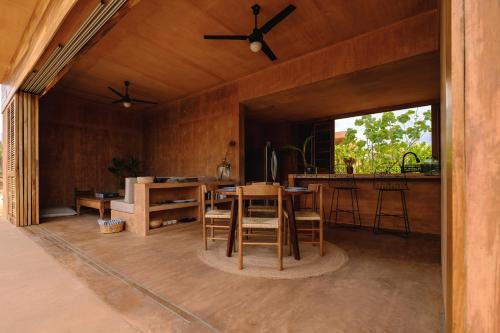 a dining room with a table and a kitchen at Mazul Puerto Escondido in Tlachicón