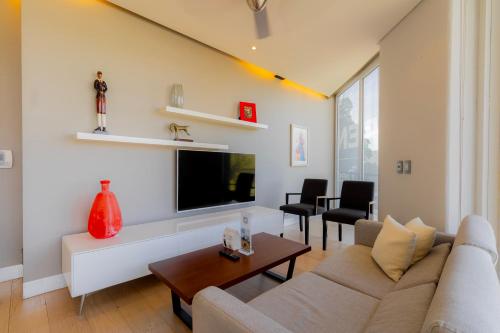 a living room with a couch and a tv at Capitalia San Angel Inn in Mexico City