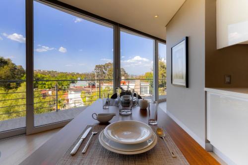 a dining room with a table and large windows at Capitalia San Angel Inn in Mexico City
