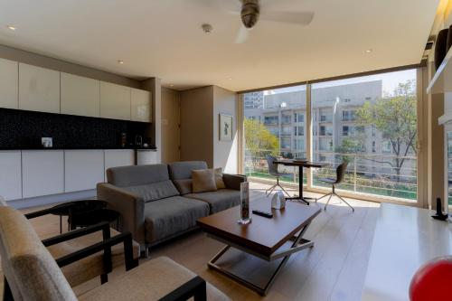 een woonkamer met een bank en een tafel bij Capitalia San Angel Inn in Mexico-Stad