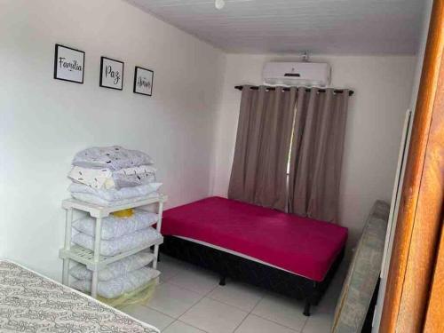 a small room with a red bed and a curtain at Casa de Veraneio IOS in Ilhéus