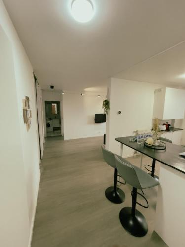 ein Esszimmer mit einem Tisch und Stühlen in einem Zimmer in der Unterkunft Appartement Proche U Arena et La Défense in Nanterre