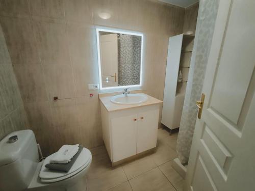a bathroom with a toilet and a sink and a mirror at Poris puesta de sol 2 in Santa Cruz de Tenerife