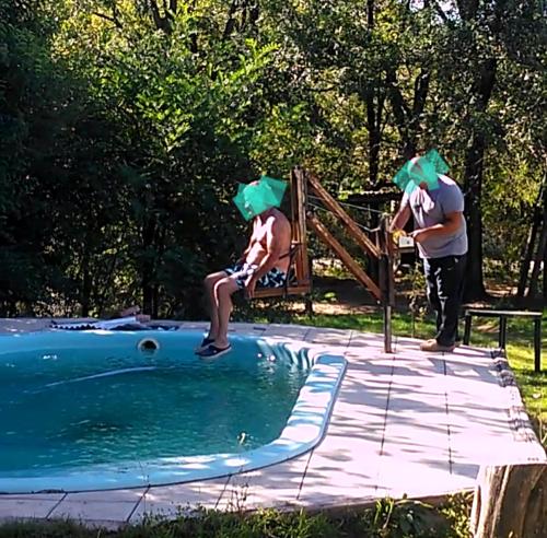 two people with green hair standing next to a pool at cabañas aromas de las sierras in El Volcán