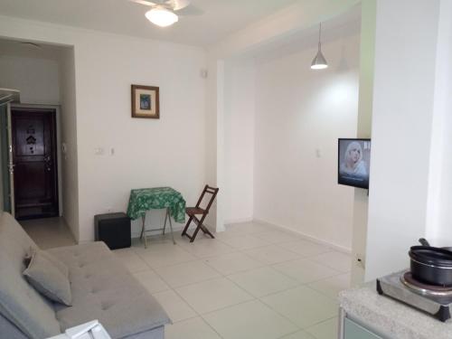 a living room with a couch and a table at Apartamento do Bruno - 1 quarto e sala predio vista ao mar- frente a praia do gonzaga in Santos