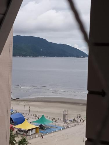 a view of a beach with people on the sand at Apartamento do Bruno - 1 quarto e sala predio vista ao mar- frente a praia do gonzaga in Santos