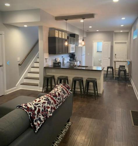 een woonkamer met een bank en een keuken bij Housepitality - The Urban Roost 2 - Location in Columbus