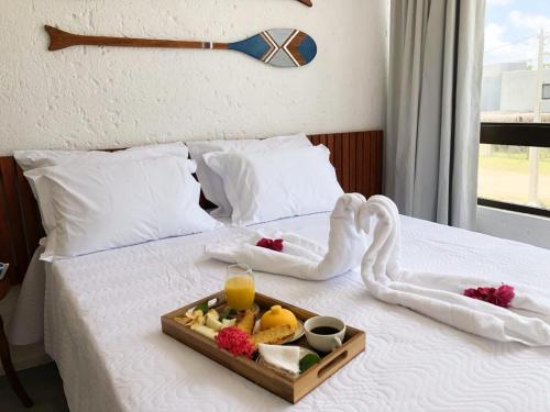 a tray of fruit on top of a bed at Refúgio a Poucos Passos do Mar l Milagres Hospedagens in Pôrto de Pedras