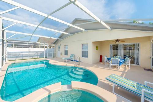 a large swimming pool with a patio with a table and chairs at 4br/3ba Disney Area Luxury Resort with pool/spa in Orlando