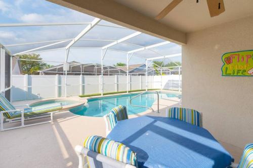 a patio with a pool and a table and chairs at 4br/3ba Disney Area Luxury Resort with pool/spa in Orlando