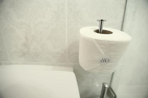 a bathroom with a toilet paper dispenser and a toilet paper holder at The White Suites in Adamas