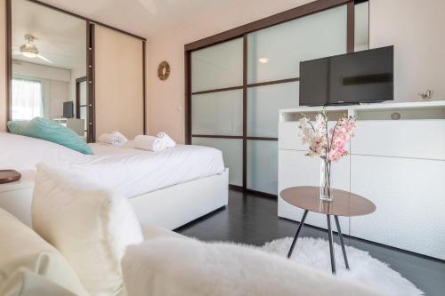 - une chambre avec 2 lits et une table ornée d'un vase de fleurs dans l'établissement REVON - City center flat, à Annecy