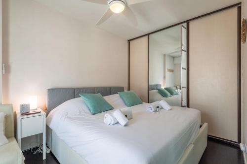 une chambre avec un grand lit blanc avec des oreillers verts dans l'établissement REVON - City center flat, à Annecy