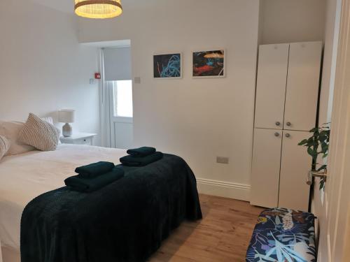 a bedroom with a bed with black towels on it at Lovely Seafront 2 bed flat in Aberystwyth in Aberystwyth