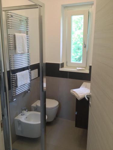 a bathroom with a sink and a toilet and a window at Casa Maria in Bergamo