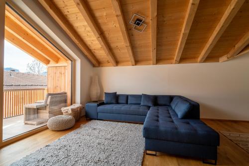 a living room with a blue couch and a large window at Neu! Auszeit in der Bergen in Wertach