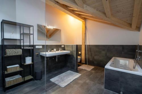 a bathroom with a sink and a bath tub at Neu! Auszeit in der Bergen in Wertach