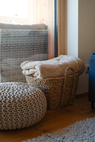 a basket of towels sitting on the floor next to a window at Neu! Auszeit in der Bergen in Wertach