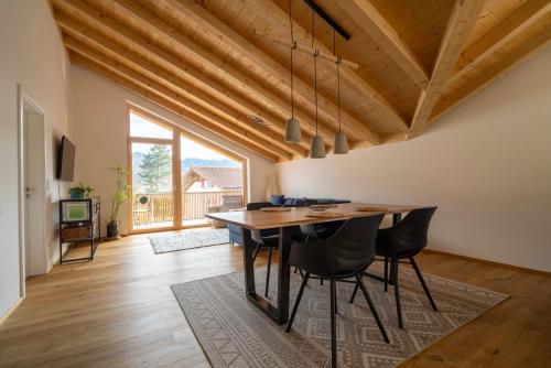 a dining room with a wooden table and chairs at Neu! Auszeit in der Bergen in Wertach