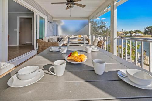 a table with a plate of food on a balcony at 5 Bed3bath waterfront pool home with full gym, office, and heated pool! in Hernando Beach