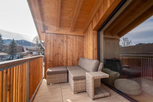 a screened in porch with a chair and a table at Neu! Auszeit in der Bergen in Wertach