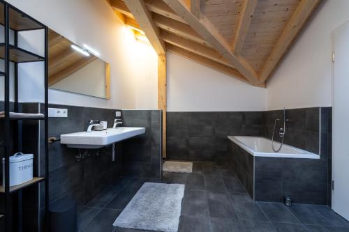 a bathroom with a sink and a bath tub at Neu! Auszeit in der Bergen in Wertach