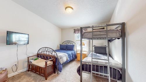 a bedroom with two bunk beds and a television at New! Grand Manor - Close to Tamarack and Lake Cascade - Pet friendly - fenced yard - trailer parking in Donnelly
