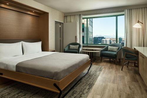 a hotel room with a bed and a desk and chairs at The Westin Denver Downtown in Denver