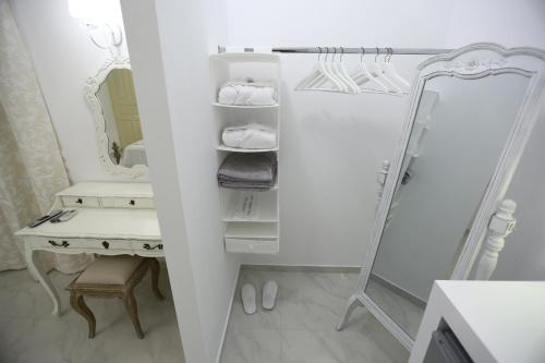 a dressing room with a mirror and a dressing table at The White Suites in Adamas