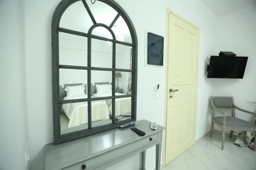 a mirror on a wall in a room with a bed at The White Suites in Adamas