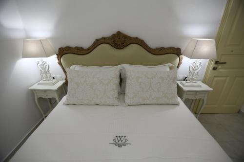 a bedroom with a bed with two nightstands and two lamps at The White Suites in Adamas