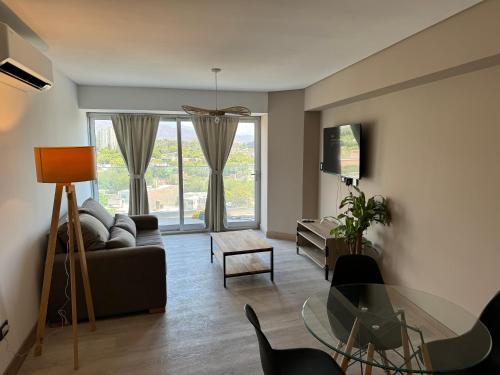 a living room with a couch and a glass table at Depto con vista increíble a la ciudad y cordillera , con balcón in Mendoza