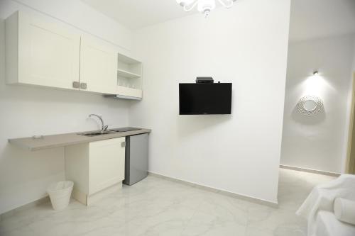 a white kitchen with a sink and a counter at The White Suites in Adamas